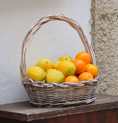 Straw basket full of lemons and oranges
