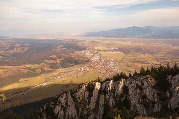 Golden sunlight illuminates the vast landscape from a rocky vantage point, showcasing a charming...