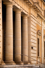 Exterior view of a historic building in Pisa with large stone columns