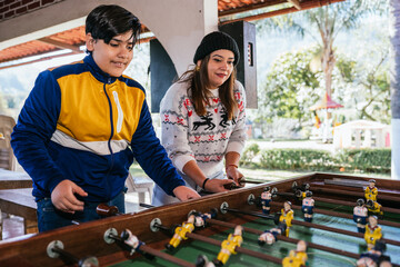 Happy family playing foosball during christmas camping vacation