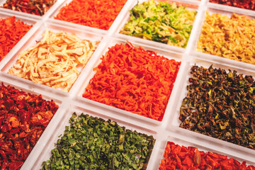 A white tray with a variety of vegetables including carrots, broccoli, and lettuce. The vegetables are in different colors and sizes