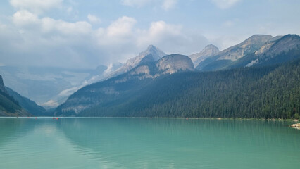 The iconic Lake Louise in summer located in Alberta, Canada with blue sky background overlooking the stunning turquoise lake.