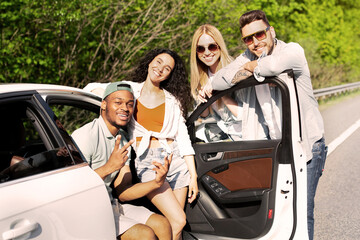 Summertime road trip, traveling with friends, joyful vacation concept. Group of diverse young...