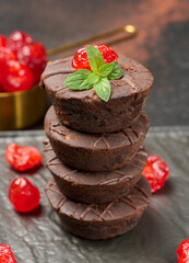 A tower of moist chocolate brownies, crowned with vibrant red cherry and fresh mint