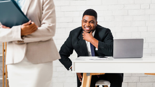 Sexual molesting concept. Perverted African American businessman ogling at his female subordinate in office