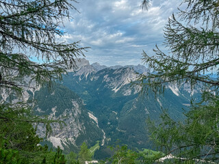 Conifer tree branch frames scenic view of rugged mountain peak Mojstrovka in remote Julian Alps...