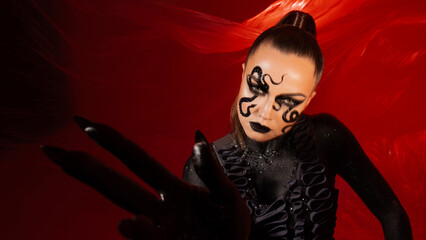 Snake woman, stylish and daring woman, snake pattern makeup, bright photo on a red background,...