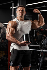 Muscular man holding container with fitness nutrition, protein, whey. Sport nutrition