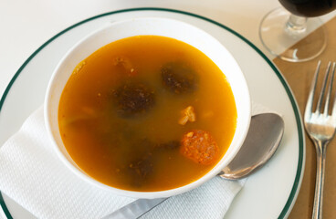Bowl of traditional spanish dish Lentils a la Riojana - thick spicy stew with lentils, vegetables, sausages and meat