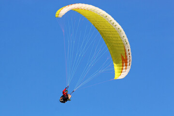 Paraglider flying in a blue sky