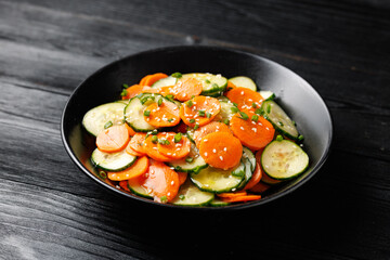 Asian style cucumber and carrots salad with sesame seeds, sweet and sour dressing and spring onions