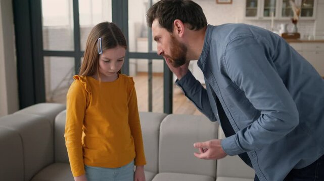 Annoyed Caucasian dad man father talk scream at offended little girl daughter kid at home angry male parent scolding guilty child schoolgirl for misbehavior punishment family argument domestic abuse
