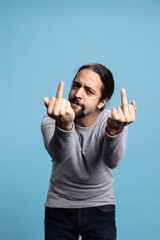 Offensive guy showing the middle finger in front of the camera and being impolite, acting...