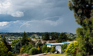 A thin tornado over alexandra town new zealand stormy dark dramatic sky