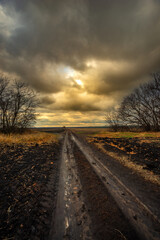 Big blue and orange clouds , over the field , sunlights through the clouds in the sky.Beautiful landscape on the field .Agriculture field and the sky.Sunset on the sky withot the sun.Orange sky nature