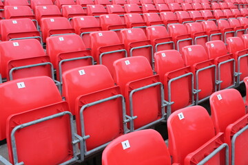 Empty red seats in stadium row in lines