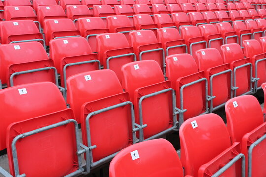 Empty red seats in stadium row in lines
