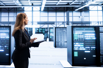 Computer scientist in data center checking rigs and hardware, doing checkup. Woman walking in high...