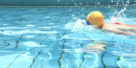 Person Swimming in Pool with Yellow Swim Cap