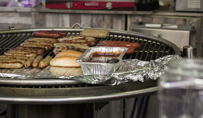 Grilling various sausages and meats at a backyard cookout during a sunny afternoon gathering