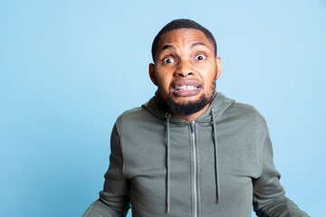 African american furious guy is getting into an argument and yelling in studio, serious aggressive person getting irritated. Frustrated man with anger issues being displeased, trauma.