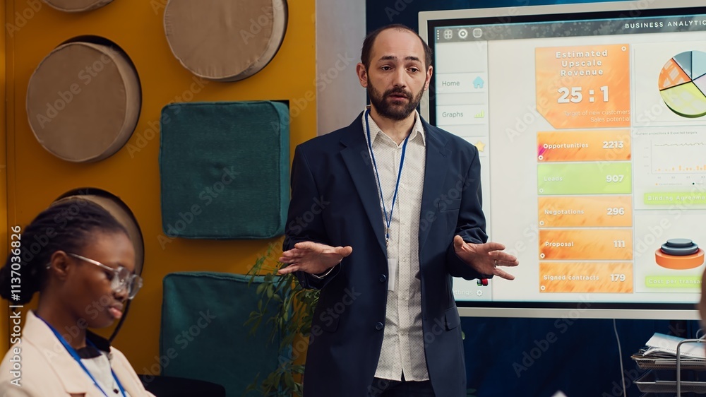 Poster management consultant gathering his employees for a status update meeting in boardroom, interactive 