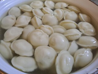 Boiled dumplings in water for culinary and cooking content. Pelmeni, popular Eastern European dish
