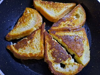 Golden brown french toast slices frying in a pan for breakfast delight