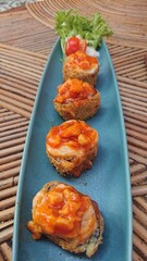 Fried Sushi Rolls with Sauce and Fresh Vegetables at bamboo table
