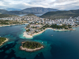 An aerial view of Ksamil resort village surrounded by blue waters and majestic mountains. Albania