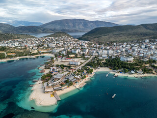 An aerial view of Ksamil resort village surrounded by blue waters and majestic mountains. Albania