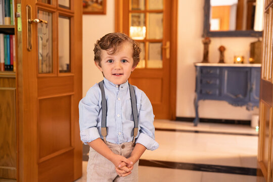 Portrait of young boy dressed formally with suspenders in elegant room