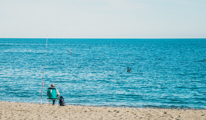 A Peaceful Day at the Beautiful Beach Enjoying Fishing by the Tranquil Sea under the Sun