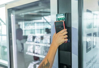 Traveler using mobile phone for easy payment at airport kiosk