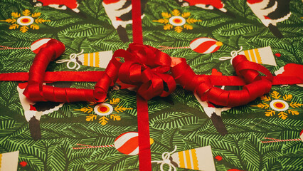 A festive Christmas gift wrapped beautifully with a vibrant red ribbon, perfect for the season