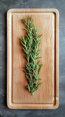 Placing a Fresh Sprig of Rosemary on a Bare Wooden Board for Culinary Inspiration and Natural Aesthetics