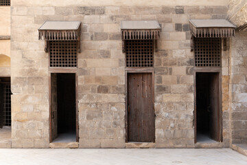 a section of the Nasser Mohammed Mosque and three identical doorways with wooden frames.