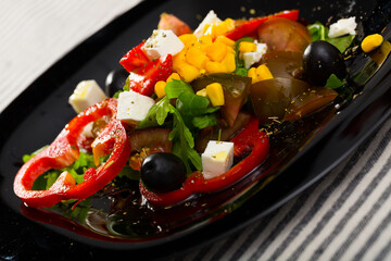 Fresh salad with vegetables, strawberries and feta cheese at plate..