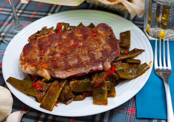 Spicy medium rare roasted veal entrecote with baked green beans and sweet red pepper