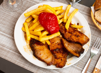 Delicious pork with boiled potatoes and stewed peppers on a plate