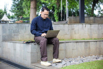 Male Wear Formal Style Working Using Laptop While Sitting on Bench