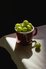 Gooseberries in a red mug and natural sunlight