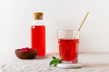 Raspberry drink in the glass on the light background.
