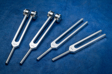 Set of weighted and unweighted metal tuning forks used for tuning musical instruments, sound therapy, chakra healing or relaxation.