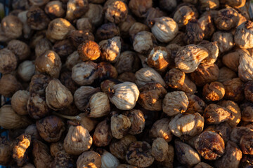 Close-up of sunlit dried figs in warm tones, showcasing organic texture and natural patterns. Concept of healthy food, dried fruits, nutrition, and Mediterranean agricultural harvest. High quality
