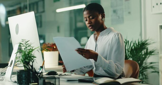 Black woman, documents and reading by computer in office for review with proposal, project or admin. Person, paperwork and pc for research, typing and feedback for perspective at creative agency