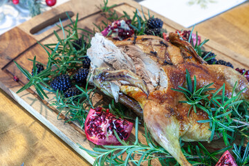Christmas goose on a bed of rosemary with blackberries and pomegranate fruit