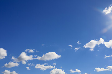 clear blue sky with a few clouds. The sky is very bright and the clouds are scattered throughout