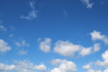 clear blue sky with a few clouds. The sky is very bright and the clouds are scattered throughout