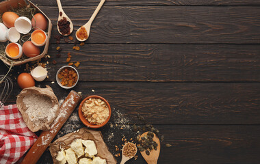 Baking background with organic eggs, flour, wheat grains, oatmeals, butter, raisins and rolling pin...